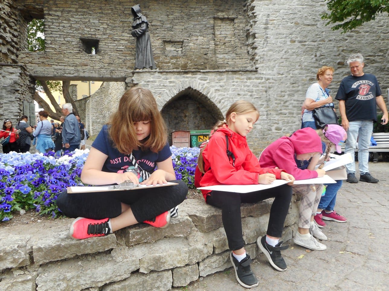 Fotol on kujutatud Neitsitorni hoovis müüril istuvaid ja otse natuurist joonistavaid õpilasi joonistavad müüril istuvad