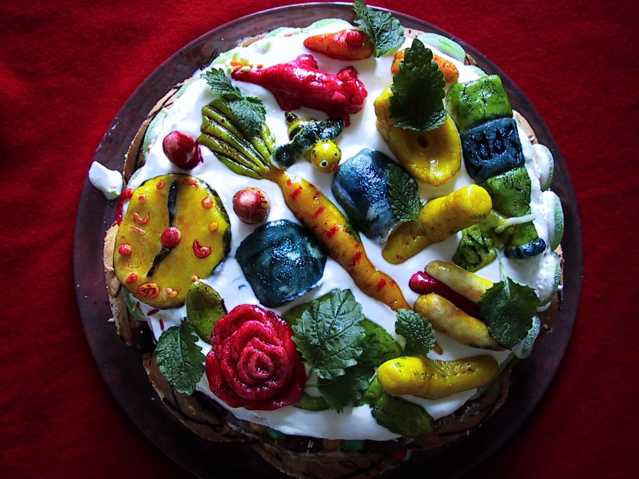 Martsipanist voolitud ja käsitsi värvitud objektidega kaetud ümmargune tort
