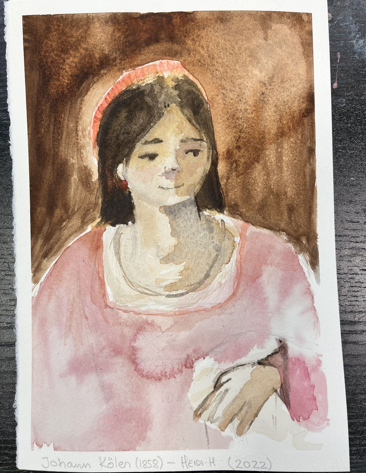 Akvarellil on kujutatud tumedapäise naise portreed käega, roosas rüüs ja umbra tooni taustal